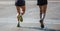 Marathon running race, two runners on city roads, detail on legs