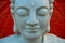 Marble Buddha face on orange background