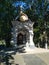 marble chapel with the icon of the Virgin Mary surrounded by green trees