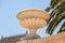 Marble flowerpot on a background of palm and sky