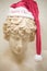 A Marble Greek Statue With Santa Hat