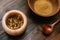 Marble mortar with dried chamomile for natural cosmetics. Clay bowl with yellow powder or clay and flowers on a wooden background