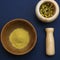 Marble mortar with dried chamomile for natural cosmetics. Clay and glass bowls with yellow powder or clay and flowers. Flat lay,