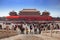 Marble pattern in front of a crowded square inside the Palace Museum in Beijing, China, facing a red gate with a brown