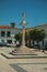 Marble pillory and sculpture on top in square with old building