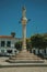 Marble pillory and sculpture on top in square with old building