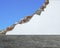 Marble slab floor with crack white bricks wall and blue sky