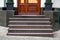 Marble staircase with granite steps to wooden entrance door.