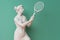 Marble statue of an ancient Greek goddess doing sports on pastel background. Tennis player sculpture. Beauty standards, ideal body