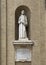 Marble statue of Saint Francis of Assisi on the left front of the Basilica of Saint Mary of the Angels in Assisi, italy.