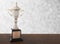 Marble trophy on wooden table on bokeh background. Winning awards with copy space