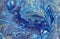 Marbled blue abstract background with golden sequins. Liquid marble ink pattern.