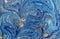 Marbled blue abstract background with golden sequins. Liquid marble ink pattern.