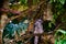 Marbled frogmouth sat on a branch, surrounded by colorful and vivid leaves