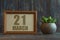 march 21st. Day 20 of month, date in frame next to succulent on wooden background spring month, day of the year concept