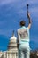 MARCH 24, 2018 - Washington DC, Female poses like Statue of Liberty in front of US Capitol,. Democracy, torch