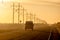 MARCH 8, 2017, NEBRASKA - Sunset over Rural Farm Country Road with pickup truck driving by row of powerlines