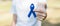 March Colorectal Cancer Awareness month, Woman holding dark Blue Ribbon for supporting people living and illness. Healthcare, hope