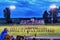 Marching band and director preforms songs at football game under twilight blue skies