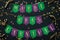 Mardi Gras carnival yellow lettering on paper handmade green and purple festive garland, black background. Holiday decoration