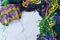 Mardis Gras border on marble background includes harlequin mask with green, gold and purple beads and matching fabrics.