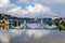 Maribor, Slovenia. View of the city and blue steel railway bridge over Drawa river reflected in water.