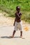 MARIENBURG, SURINAME - AUGUST 7, 2015: Boy walks at a road at Marienburg plantation in Surina