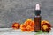 Marigold essential oil and fresh Tagetes flowers on old wooden background.Alternative medicine,aromatherapy or spa concept.