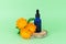 Marigold flowers and dropper bottle on birch wood slice and green background.