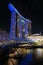 Marina Bay, Singapore - February 19, 2023 - The Helix Bridge and Marina Bay Sands Hotel illuminated in blue lights at night