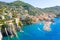 Marina and breakwater where lighthouse is located. Boat sailing to the harbor in ligurian sea, Camogli near Portofino