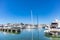 Marina Zeas in Piraeus, Greece. Many moored yachts. Reflection of boats, blue calm sea, city and sky background