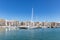 Marina Zeas in Piraeus, Greece. Many moored yachts. Reflection of boats, blue calm sea, city and sky background