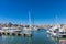 Marina Zeas in Piraeus, Greece. Many white moored yachts. Reflection of boats, blue calm sea, city and sky background