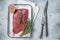 Marinatad flank beef steak with herbs and olive oil, raw meat. Gray background. Top view