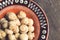 Marinated, canned mushrooms champignon in brown bowl on wooden background. Top view. Copy space.