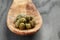 Marinated capers in wood spoon on table