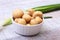 Marinated champignons in white bowl and Green onion. ready for cooking.