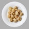 Marinated champignons on a white round plate. Light gray isolated background. Top view.