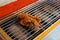 A marinated flour chicken being grilled