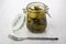 Marinated gherkins in open glass jar, fork on table