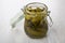 Marinated gherkins in transparent glass jar on table