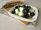 Marinated mozzarella with black olives, olive oil and mustard leaves