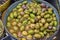 Marinated olives with herbs in a market.