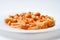 Marinated savory mushrooms on a white round plate. Light gray isolated background. View from above.