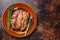 Marinated skirt bavette steaks in bbq sauce on a plata. Dark background. Top view. Copy space