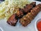 Marinated spice grilled beef and chicken kebab skewers Persian style with saffron rice on white plate