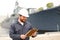 Marine deckhand talking reading documents and standing near vessel.