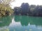A marine green body of water at rest at the bottom of the great krka waterfalls.
