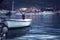 Marine port with moored boat and yachts in sea during sunset with copy space in purple toned colors